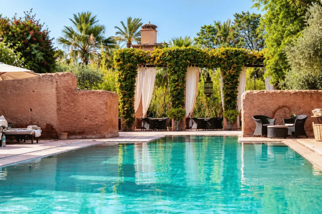 Heated outdoor pool surrounded by lush Andalusian gardens at Les Deux Tours in Marrakech.